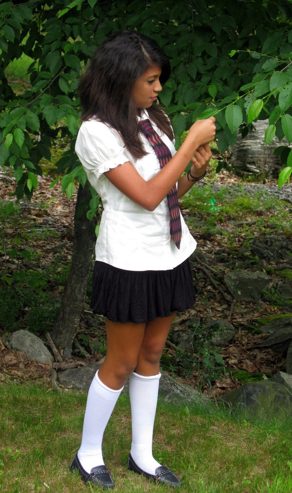 Brunette Schoolgirl wearing White Long Socks and Black Pleated Miniskirt